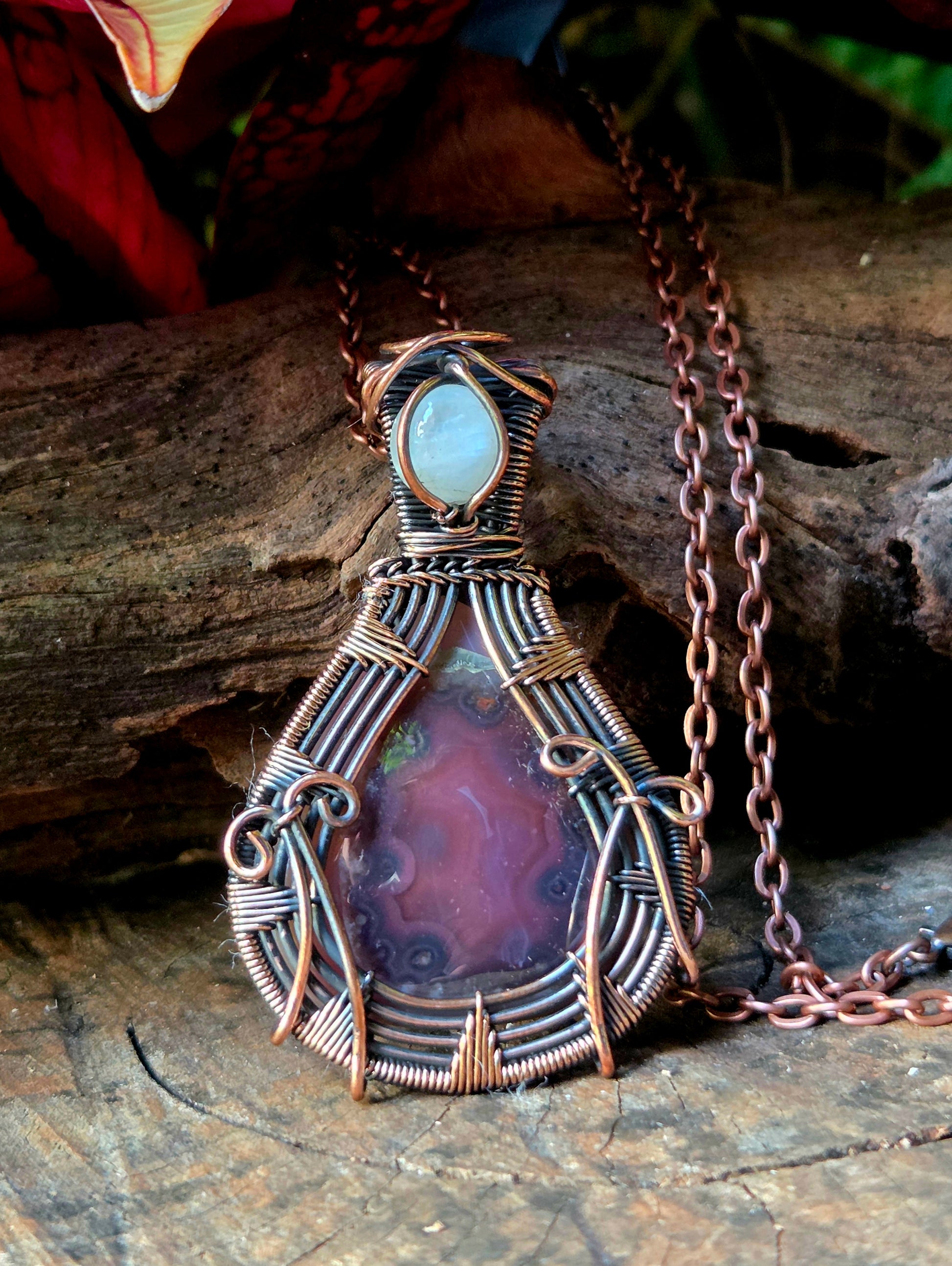 Agate and moonstone Copper necklace on a natural wooden surface with red leaves in the background 