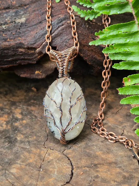 Copper necklace with quartz Pendant on a natural wooden background 