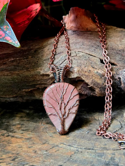 Necklace with a pink stone pendant on a wooden surface