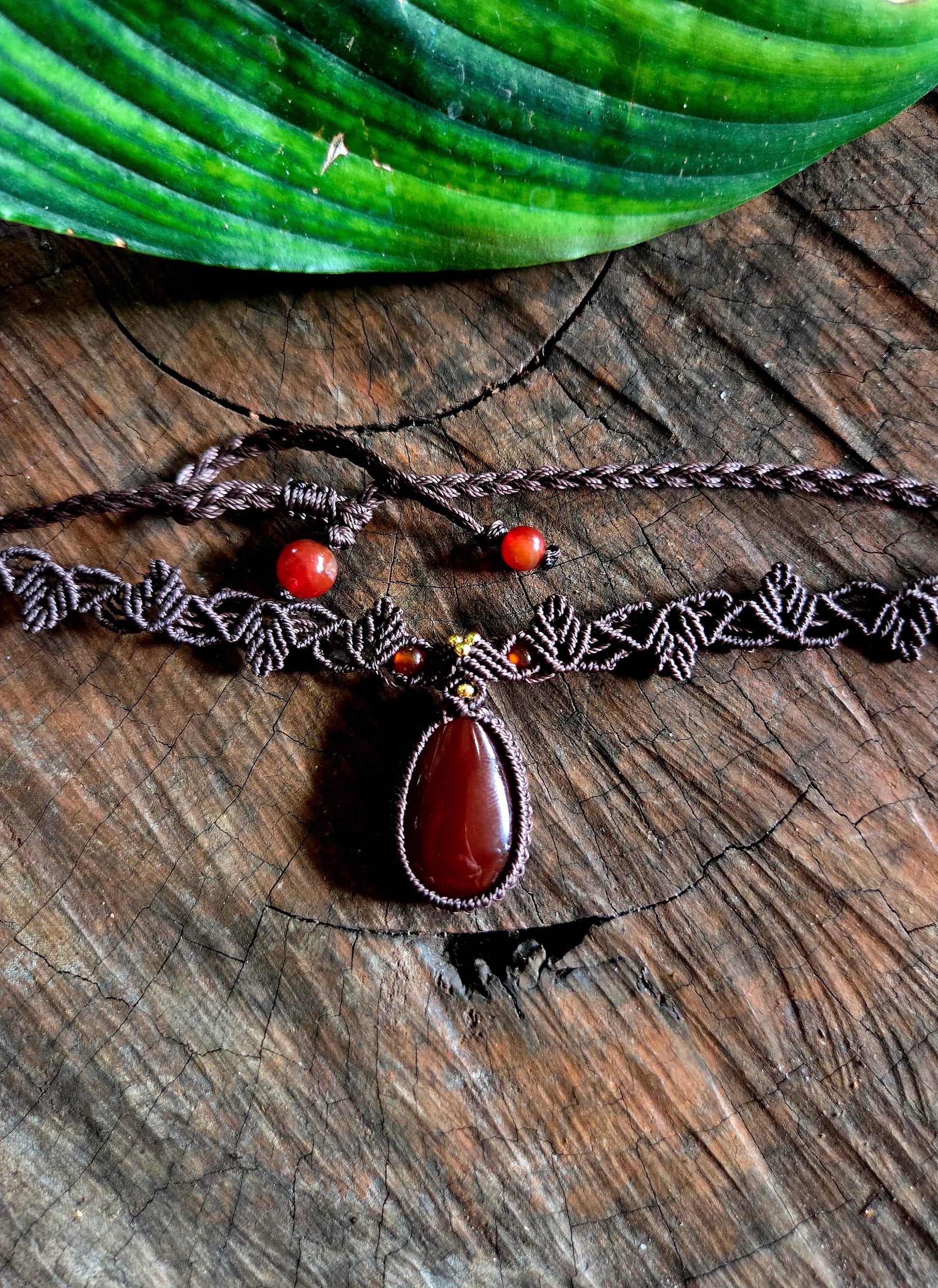 Necklace with a red pendant on a wooden surface