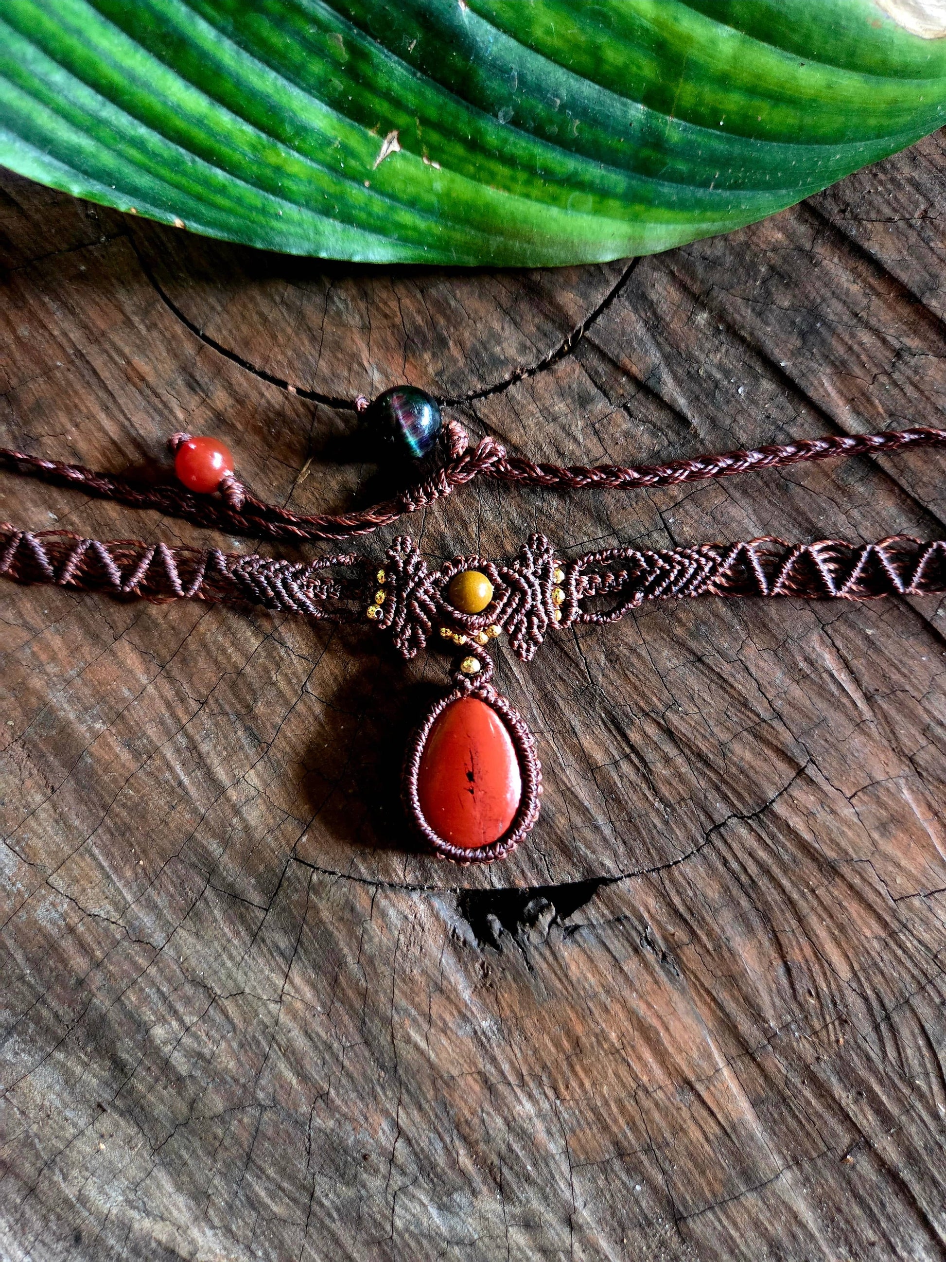 Red Jasper macrame necklace on a wooden surface
