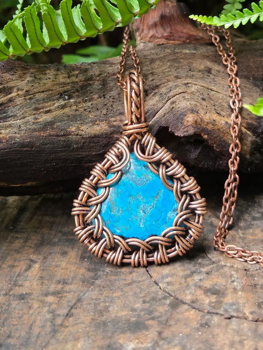 Turquoise copper necklace on a natural wooden surface background 