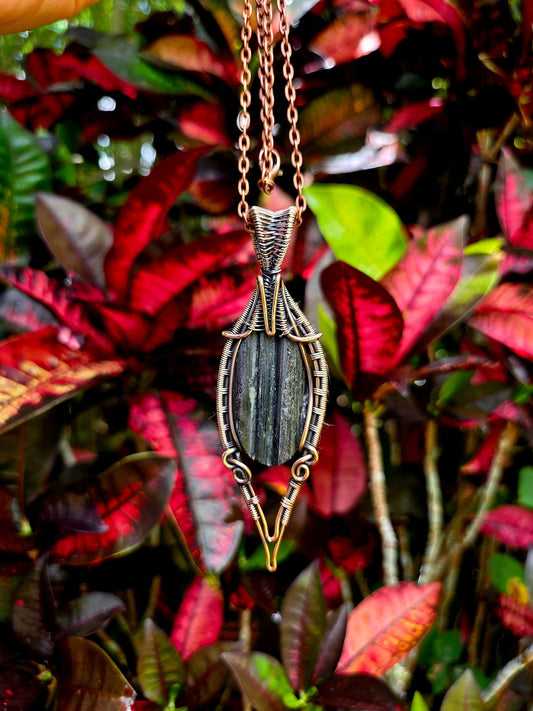 Necklace with a pendant against a background of red and green leaves