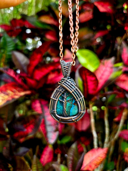 Necklace with a wire-wrapped pendant against a leafy background