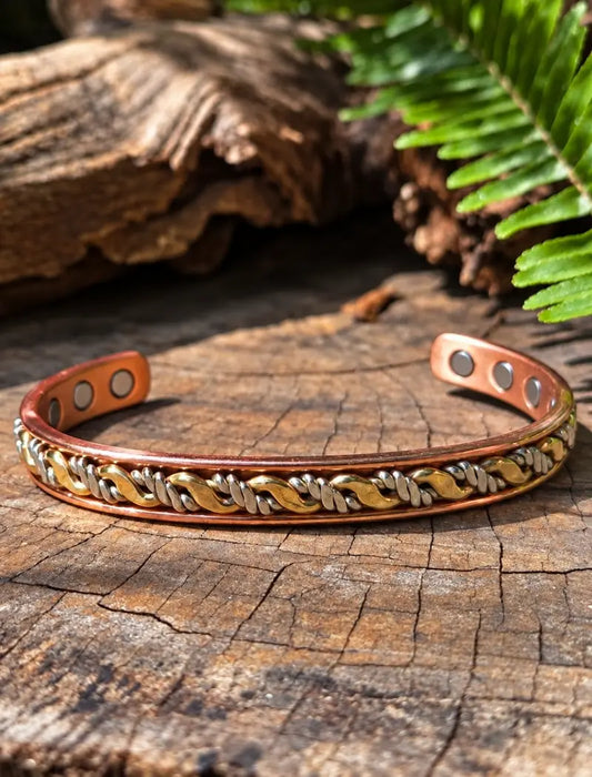 Copper Tricolour cuff bracelet on a wooden surface with ferns in the background